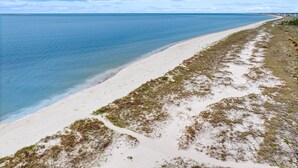 Een strand met helderblauw water en een zandstrand.