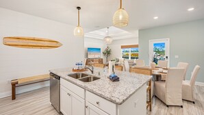 Een moderne keuken met een centraal eiland, inbouwapparatuur en een eetgedeelte met uitzicht.