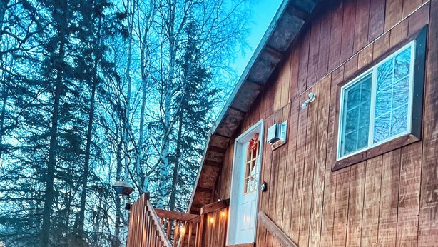 A wooden cabin with a wooden staircase leading to a deck. - Little Creek Cabin: Cozy, Adventure-Ready & Dog-Friendly (Anchorage)