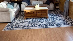 A cozy cabin-style room with a wooden ceiling, a sofa, a coffee table, and a patterned rug. - Little Creek Cabin: Cozy, Adventure-Ready & Dog-Friendly (Anchorage)