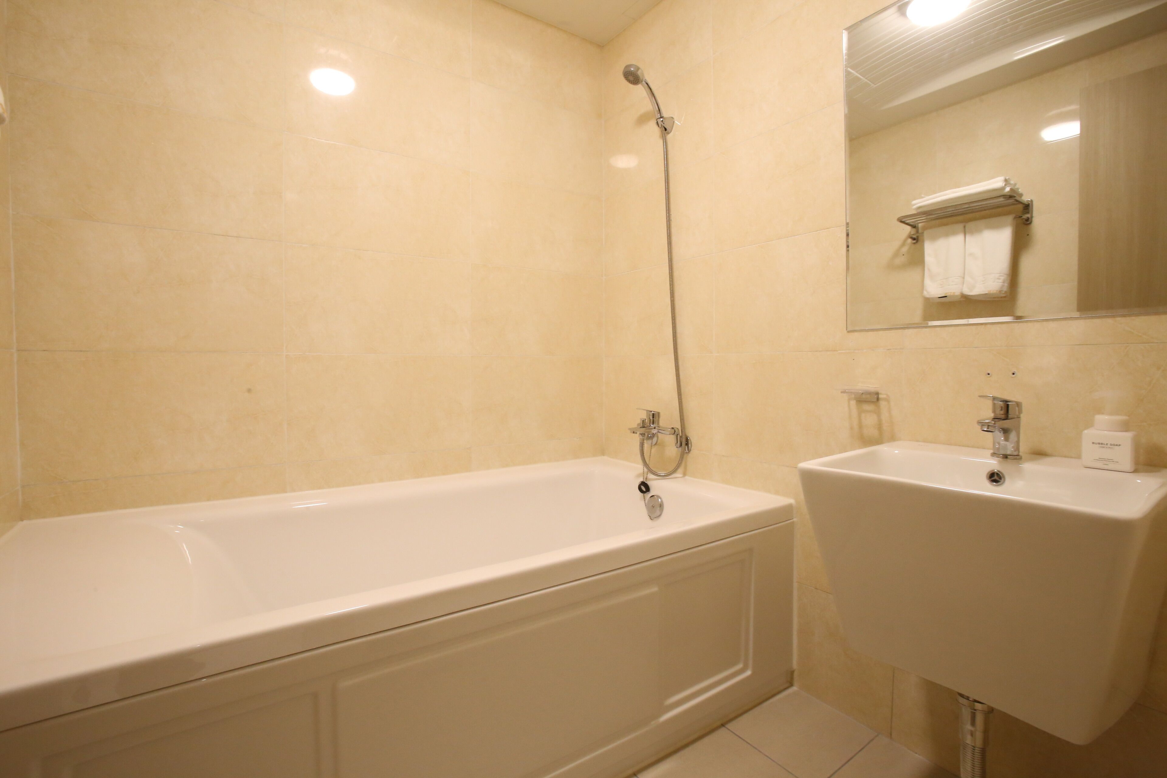 Un baño con bañera, lavamanos y espejo.