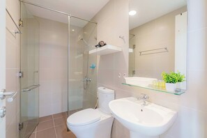 Une salle de bain moderne avec une douche à parois de verre, des toilettes, un lavabo et un miroir.