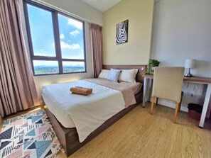 A hotel room with a bed, a desk, a chair, a window with curtains, a city view, and a wall art piece. - RAINBOW Sky Center TSN Airport (Ho Chi Minh City)