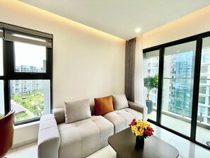 Appartement supérieur, 2 chambres, balcon, vue sur la ville | Aire de séjour | Téléviseur de 35 po avec télévision par câble