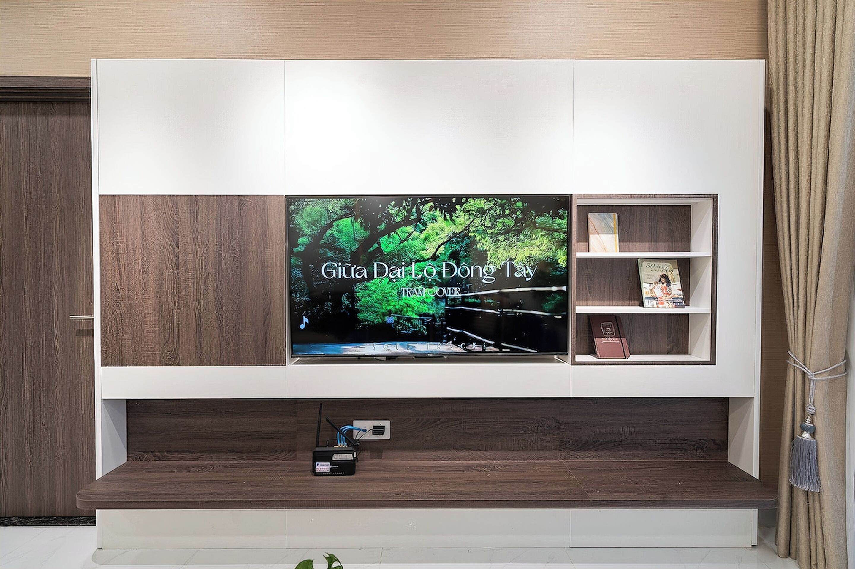 A flat-screen TV mounted on a wall with a wooden cabinet below.