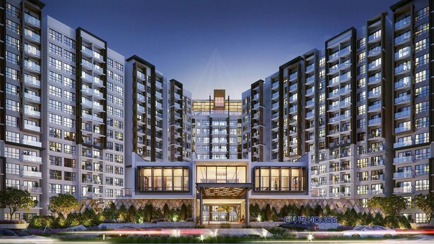 Un moderno complejo de apartamentos con varios edificios de gran altura, una entrada central con puertas de cristal y una zona ajardinada bien cuidada.