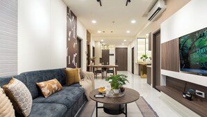 Ein modernes Wohnzimmer mit Sofa, Couchtisch und Fernseher.