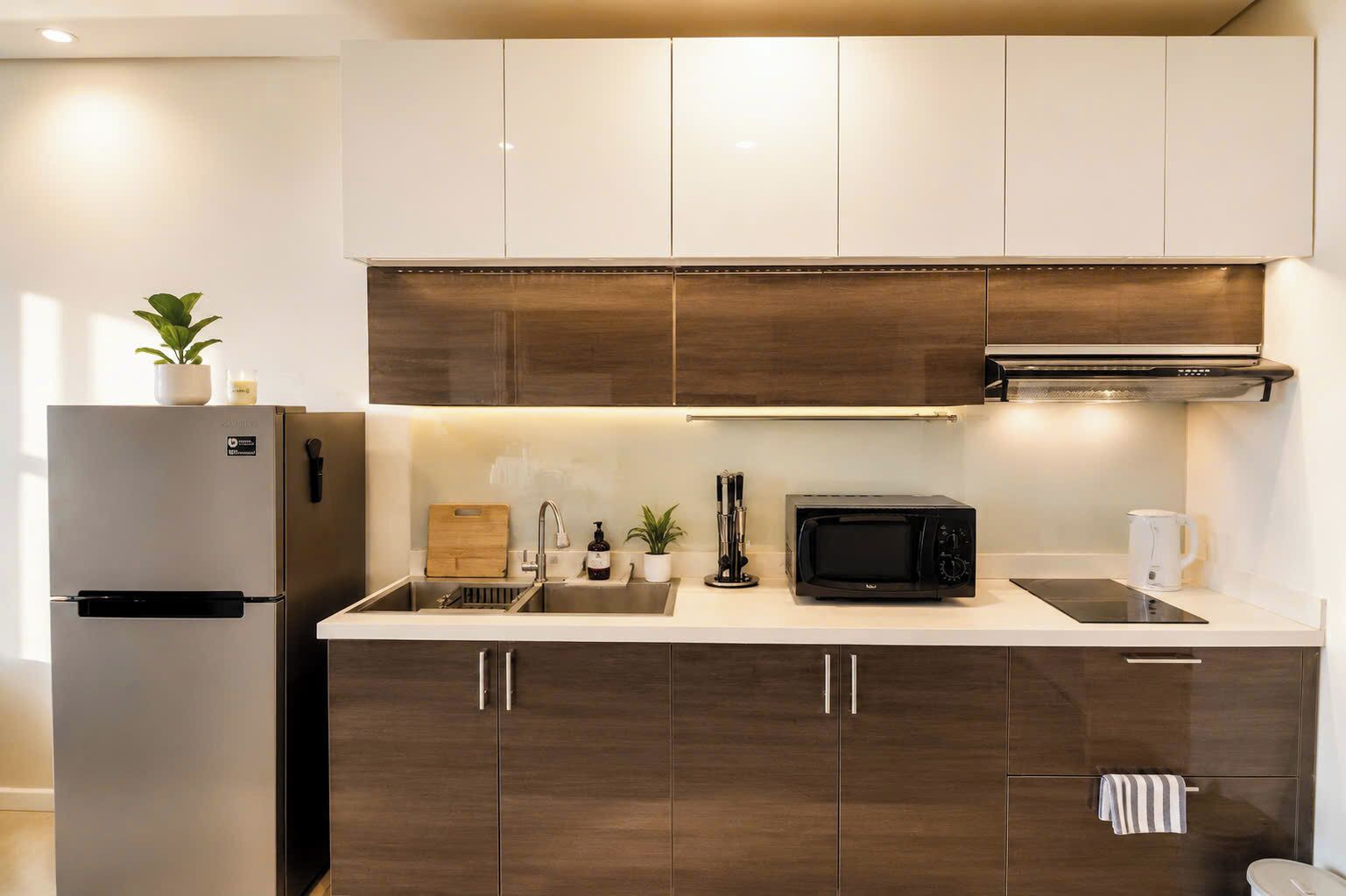 Una cocina moderna con microondas integrado, tostadora y lavabo.