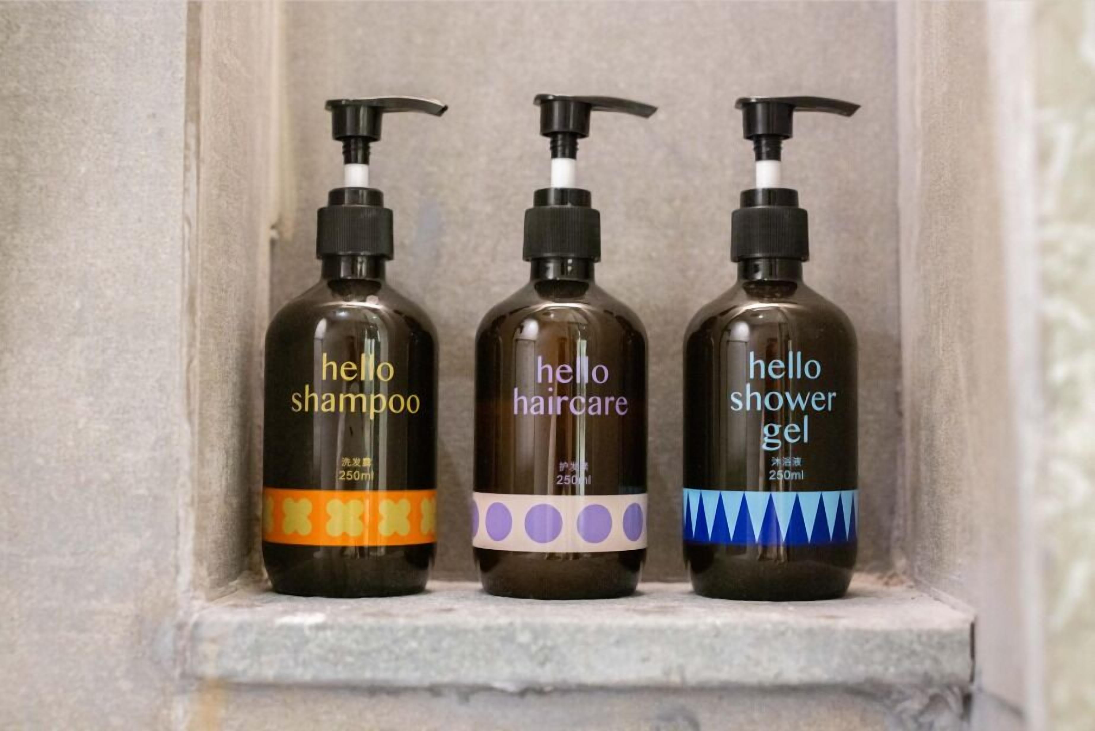 Three bottles of 'hello' haircare products on a shelf.