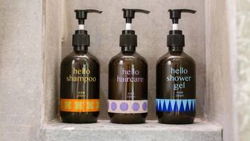 Three bottles of 'hello' haircare products on a shelf.