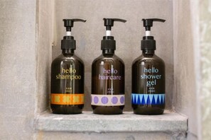 Trois bouteilles de produits capillaires de la marque « Hello » sont posées sur une étagère.