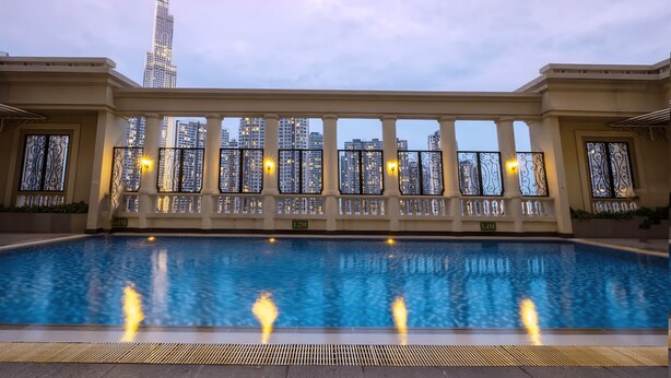 A swimming pool with a view of high-rise buildings and a tall skyscraper in the background. - GEM Residence - The Manor Central (Ho Chi Minh City)