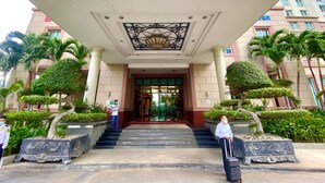 A hotel entrance with a grand entrance, steps leading up to the door, and well-maintained landscaping. - GEM Residence - The Manor Central (Ho Chi Minh City)