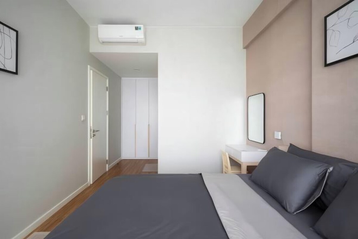 Un dormitorio moderno con cama, mesita de noche y espejo.