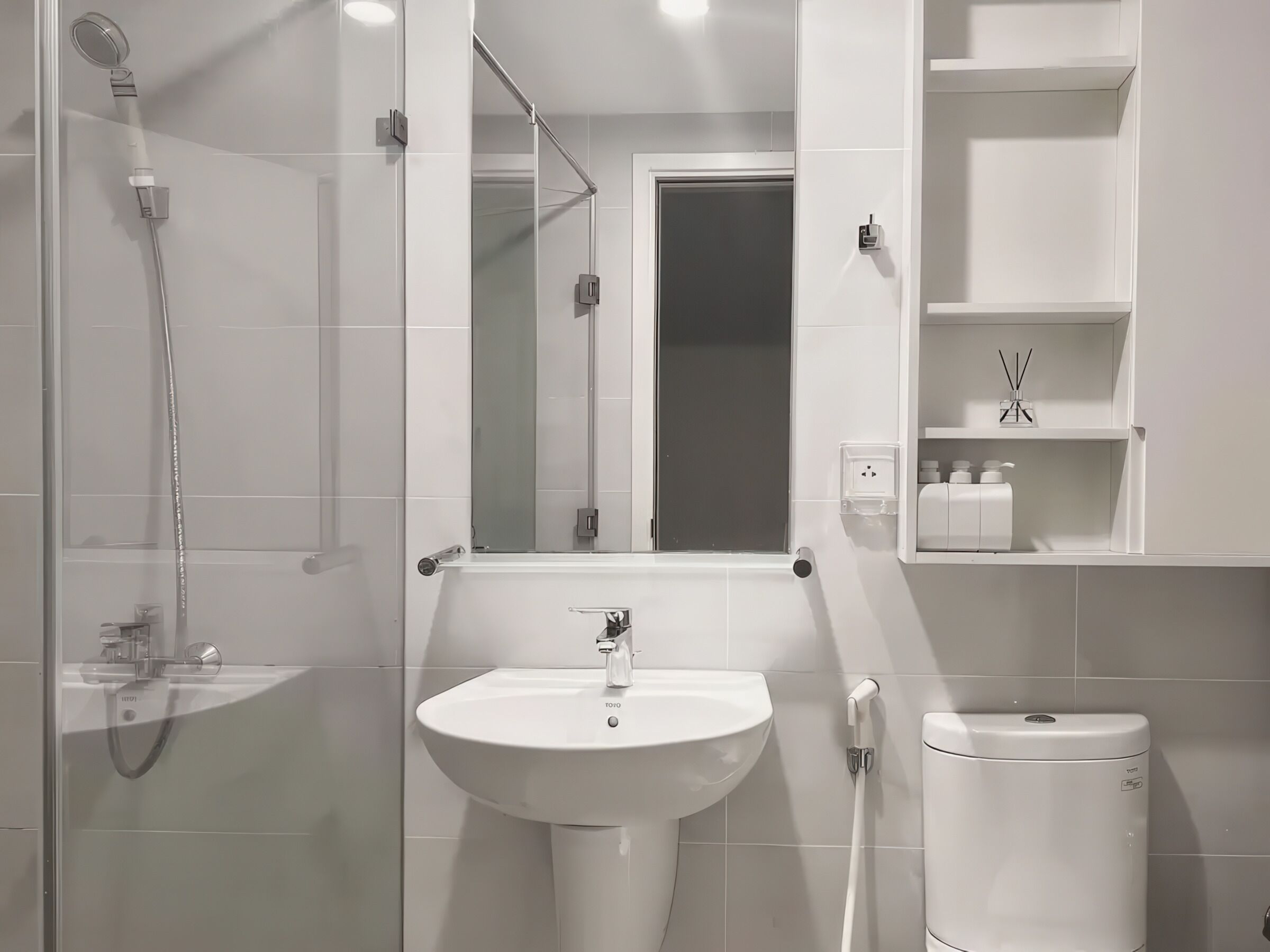 Une salle de bain moderne avec une douche à parois de verre, un lavabo blanc et des toilettes.