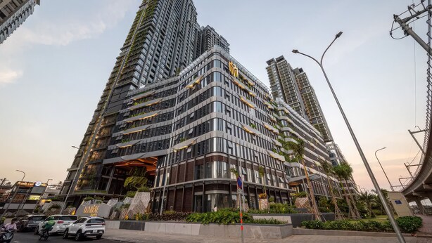 A modern high-rise building with multiple balconies and a curved facade. - Lumiere Riverside - Luxury Condo District 2 (Ho Chi Minh City)