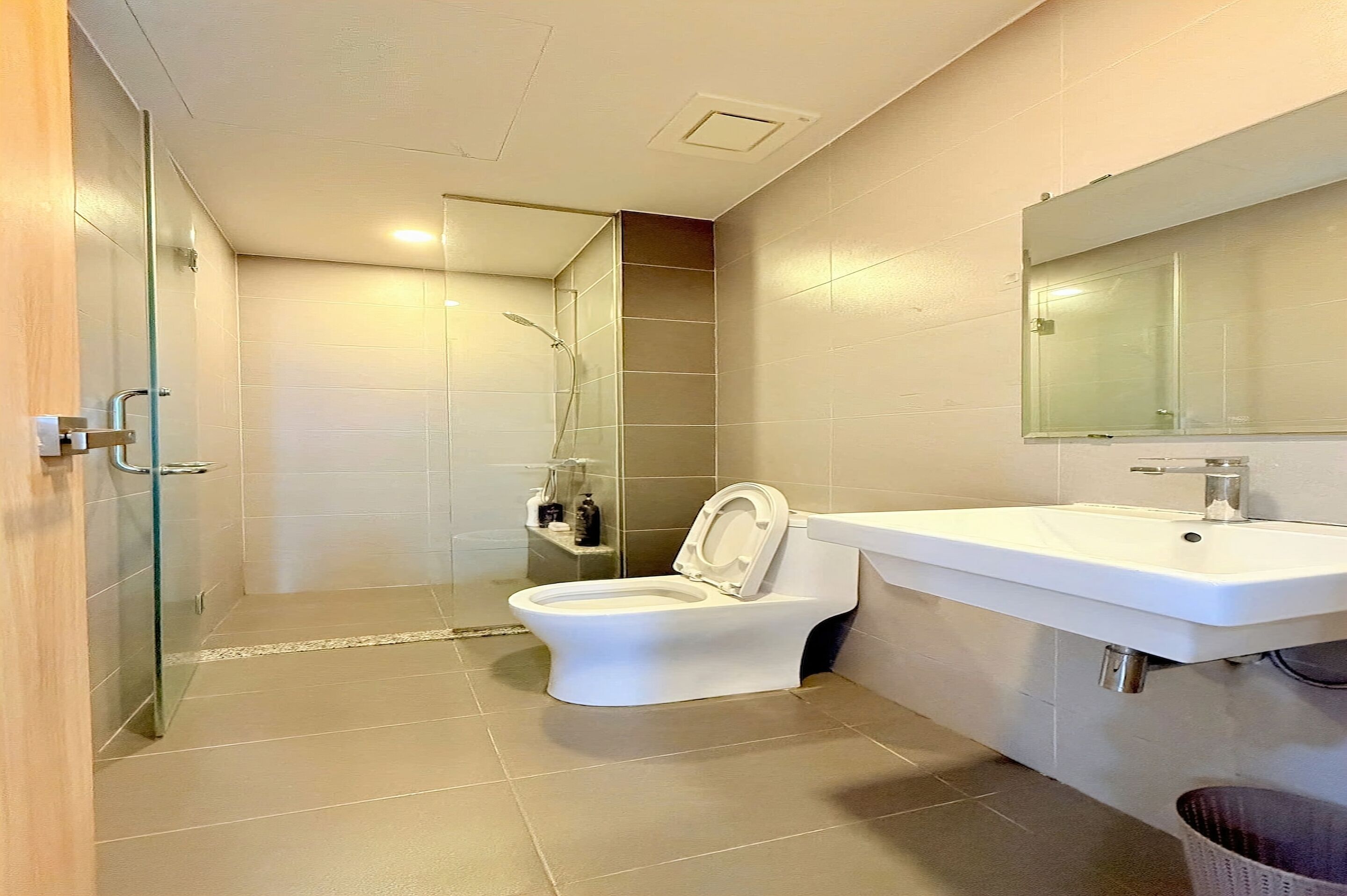 Ein Badezimmer mit Toilette, Dusche, Waschbecken und Spiegel.