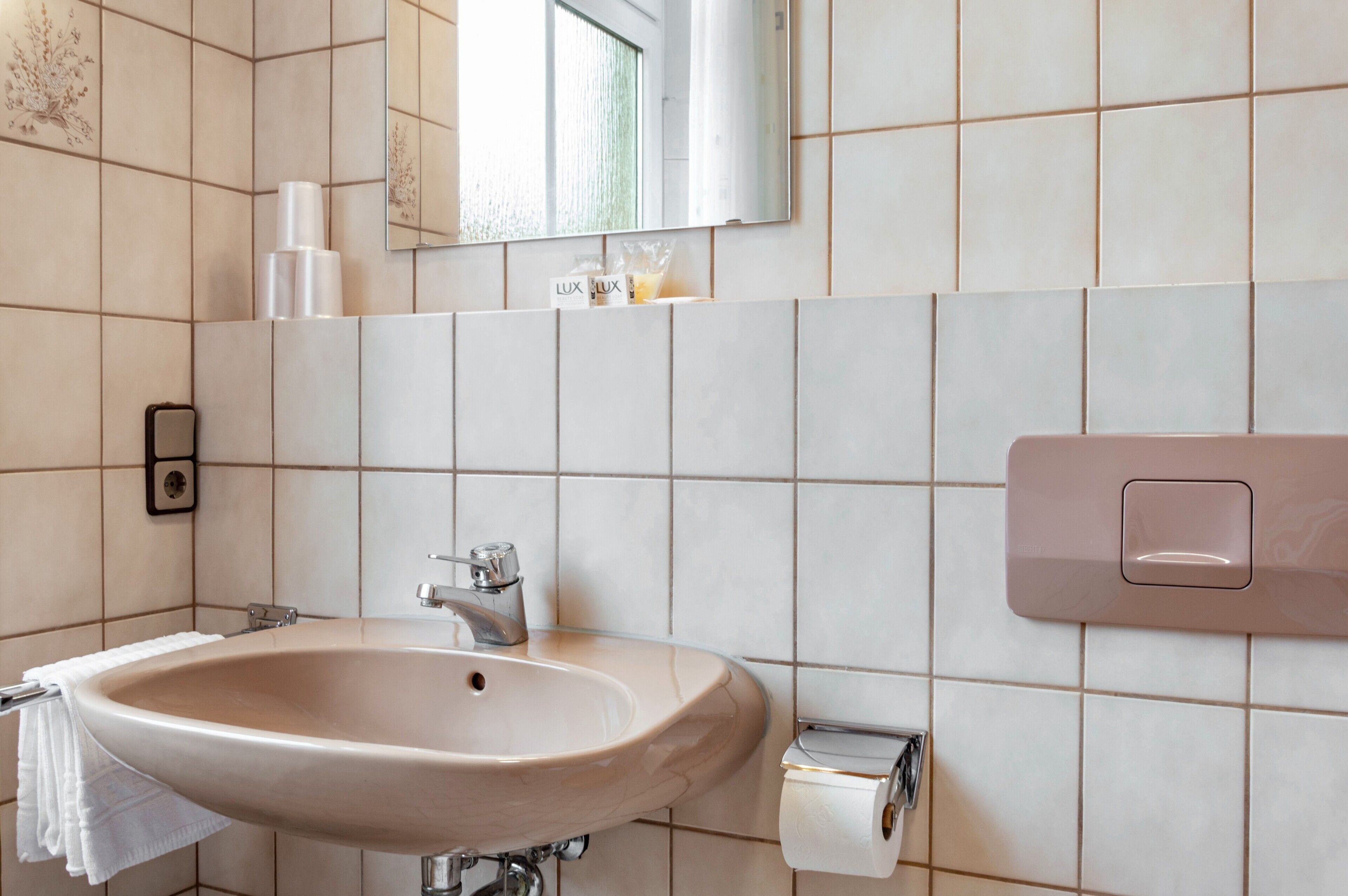 A bathroom with a sink, mirror, and towel rack.