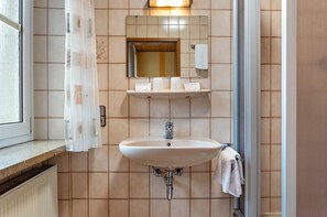 Ein Badezimmer mit Waschbecken, Spiegel und Handtuchhalter.