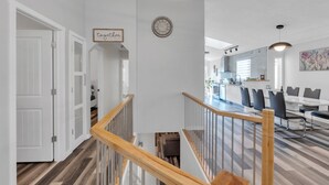 A modern interior with a staircase, a dining area, and a kitchen.