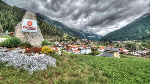 A mountainous village with a prominent rock sign labeled 'Pettneu am ARLBERG.'