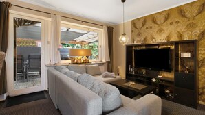 A living room with a sofa, TV, and decorative items.