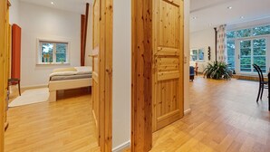 A modern bedroom with a wooden wardrobe, a bed, a window, and a view of the outdoors.