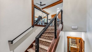 A staircase with wooden steps and metal railings, leading to a room with a view of the outside. - Breck Ski-in Retreat – Walk to Gondola & Lifts (Breckenridge)