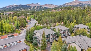 A residential area with houses surrounded by dense forest and mountains in the background. - Breck Ski-in Retreat – Walk to Gondola & Lifts (Breckenridge)