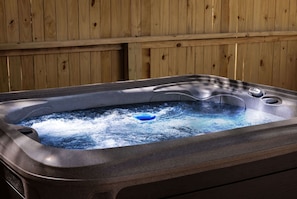 Un jacuzzi con tapa azul, frente a una pared de madera.