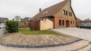A two-story house with a sloped roof, a garage, and a paved driveway.