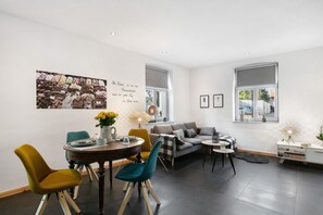 A modern living room with a dining area, a sofa, and a coffee table.