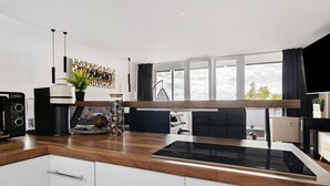 A modern kitchen with a built-in stove, a coffee maker, and a hanging plant.