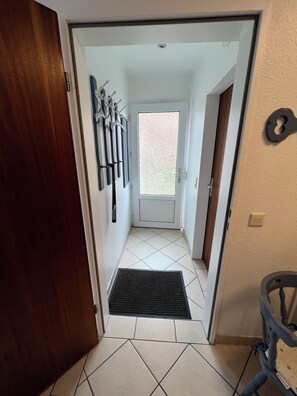 Enter a clean and simple space with a door leading to an area.