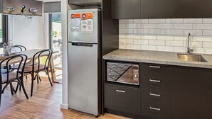Una cocina moderna con armarios oscuros, un lavavajillas Bosch y un horno empotrado.