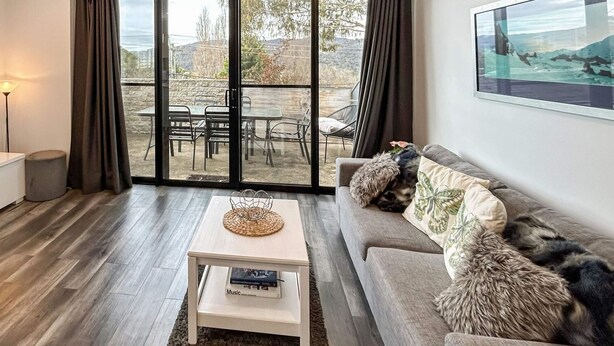 Un salon équipé d’un téléviseur, d’un canapé, d’une table basse et offrant une vue sur l’extérieur.