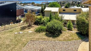 A residential area with modern houses, a view of a body of water, and a gravel pathway.