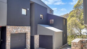 Un bâtiment moderne à deux étages, doté d’une façade en pierre et d’une porte de garage.
