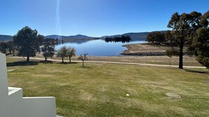 A view of a lake with surrounding trees and a clear sky. - Horizons 317 studio right on the Lake (Jindabyne)