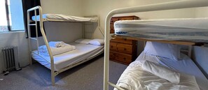 Cozy single-room accommodation with a bunk bed setup, featuring a simple layout and clean, tidy atmosphere.