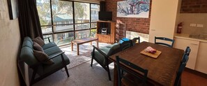 Relax in a stylish living area with a sofa set, dining table, and flat-screen TV.