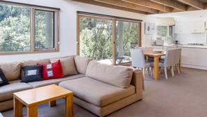 A modern living space with a sofa, coffee table, and dining area.