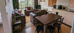 Relax in this compact living space with a sofa, kitchenette, and dining area, perfect for comfortable living and dining.