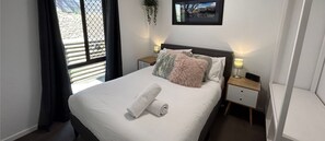 Relax in a spacious room with a large bed, bedside table, and wall-mounted picture frame.