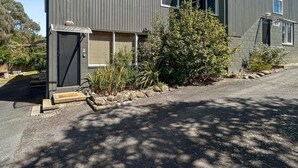 A modern building with a dark exterior, a visible door, and a small step leading to the entrance.