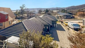 A large industrial facility with multiple buildings, including a red barn-like structure and several large warehouses with metal roofs. - Moonbah 2 two bedroom unit (Jindabyne)