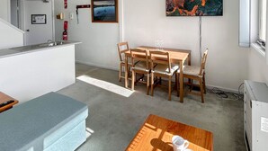 A compact living space with a kitchenette, dining area, and a small sofa. - Razorback 4 - Centrally located, self-contained 1 bedroom (Jindabyne)