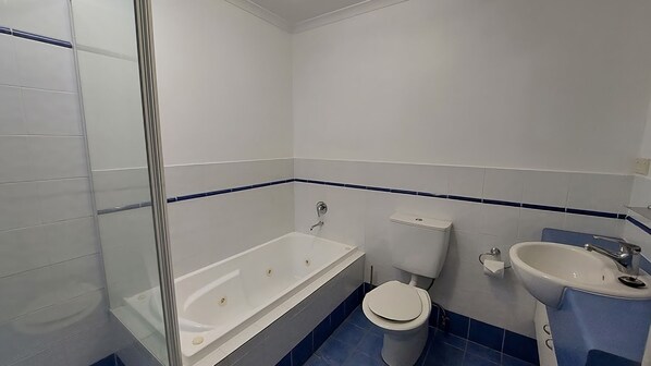 A bathroom with a bathtub, toilet, and sink.