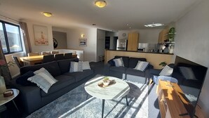 Una sala de estar moderna con dos sofás, una mesa de centro y un comedor con una mesa y sillas.
