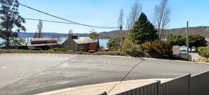 A parking area with a view of a lake and hills in the background. - Silvertrees 3 - lovely 3 bedroom centrally located (Jindabyne)